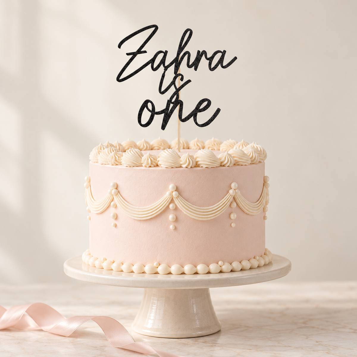 Black glitter Zahra is one personalised topper on a softly styled blush birthday cake