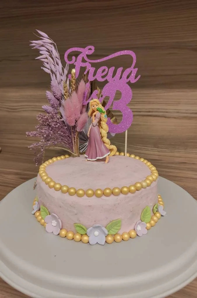 Pink personalised fairy cake topper on a pastel birthday cake