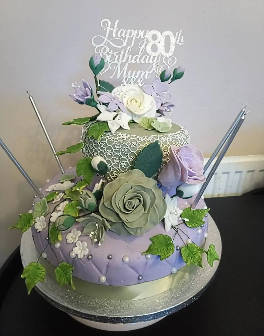 Silver personalised 80th birthday cake topper on a floral cake